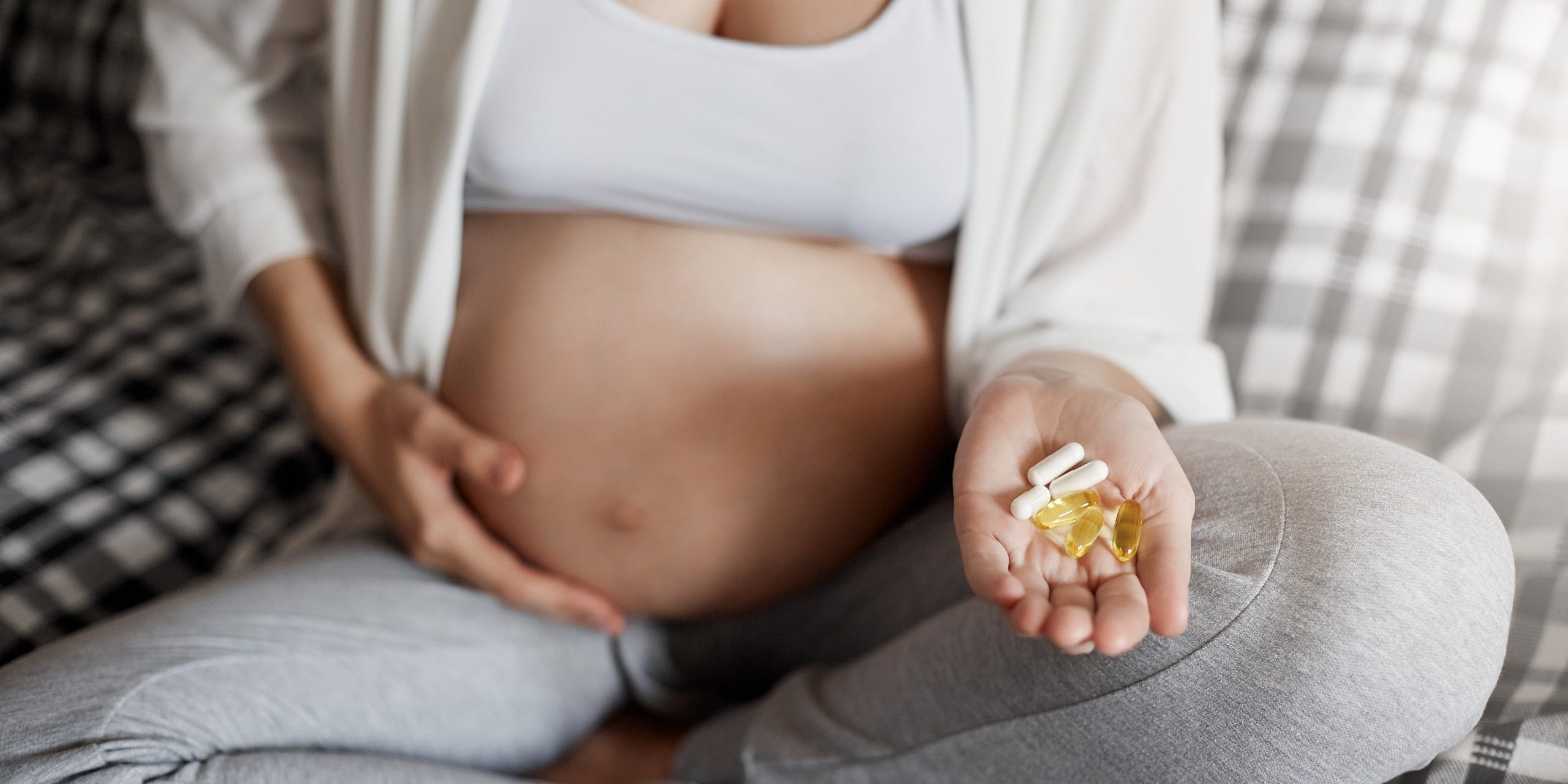 Młoda matka trzyma suplementy diety by dbac o zdrowie swoje i dziecka